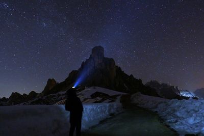 Man on rock against sky at night