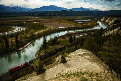 High angle view of river amidst mountains against sky