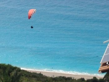 Person paragliding over sea