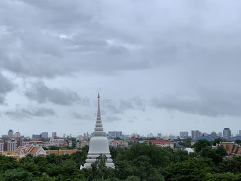 Buildings in city against cloudy sky