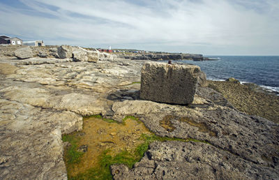 Scenic view of rocks on beach against sky