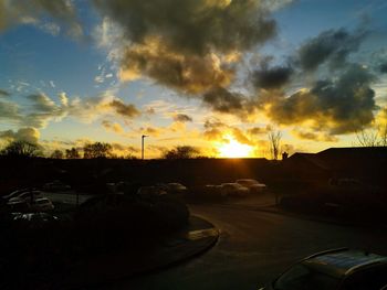 Cars on road against orange sky