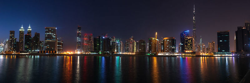 Illuminated buildings against sky at night