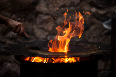 Cropped hand preparing fire pit