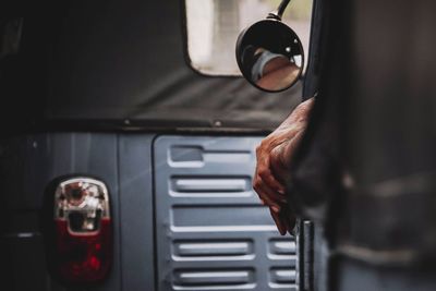 Cropped hand on vehicle window