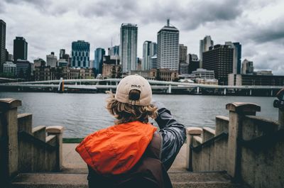 Rear view of woman with cityscape in background
