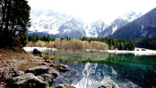 Scenic view of lake by mountains against sky