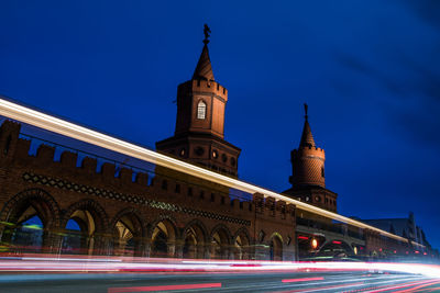 Illuminated building against blue sky at night