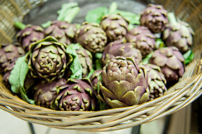 High angle view of fresh artichokes in basket at market stall