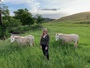 Portrait of a young woman with two wild burros, along wildlife loop drive, in custer state park