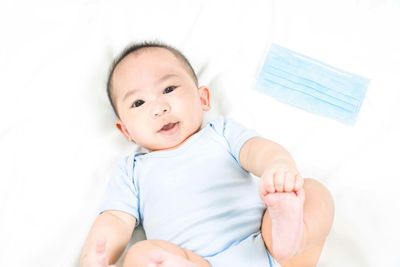 Portrait of cute baby lying on bed