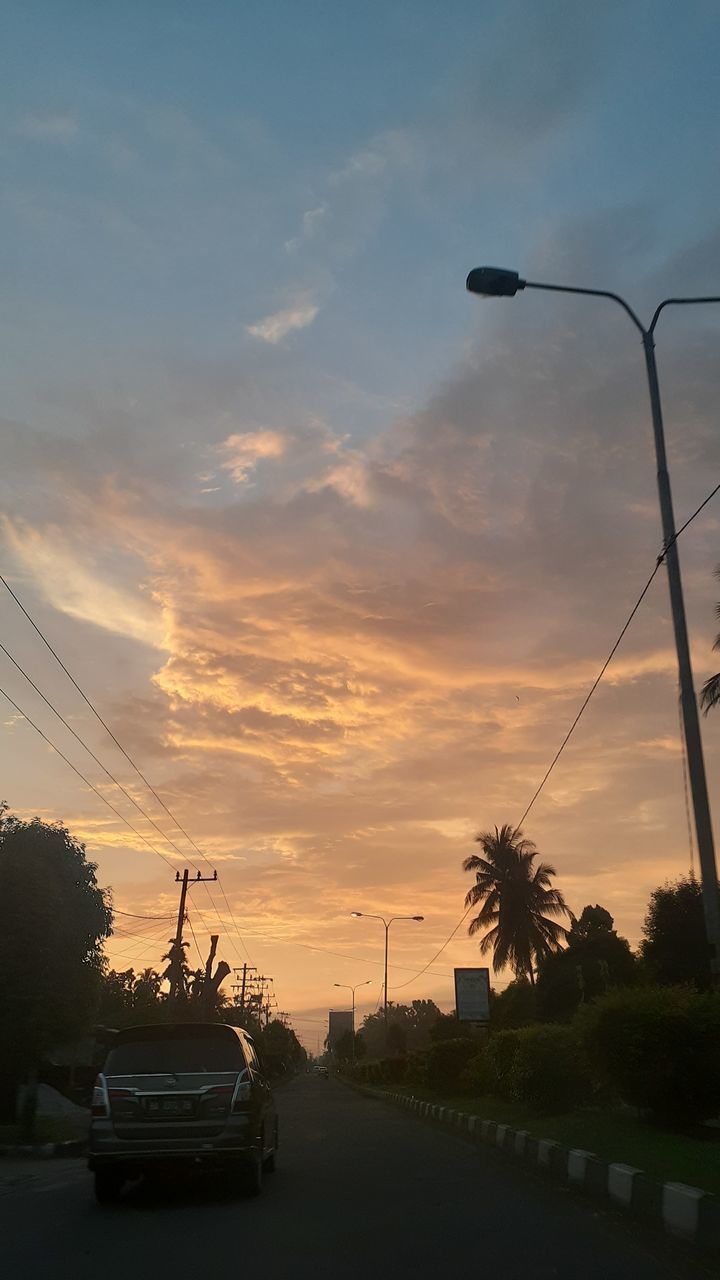 CAR ON STREET AGAINST SKY AT SUNSET