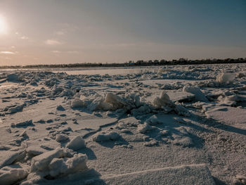 Scenic view of snow covered land against sky