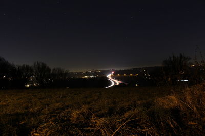 Illuminated landscape against sky at night