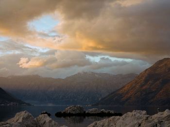 Scenic view of sea and mountains against sky during sunset