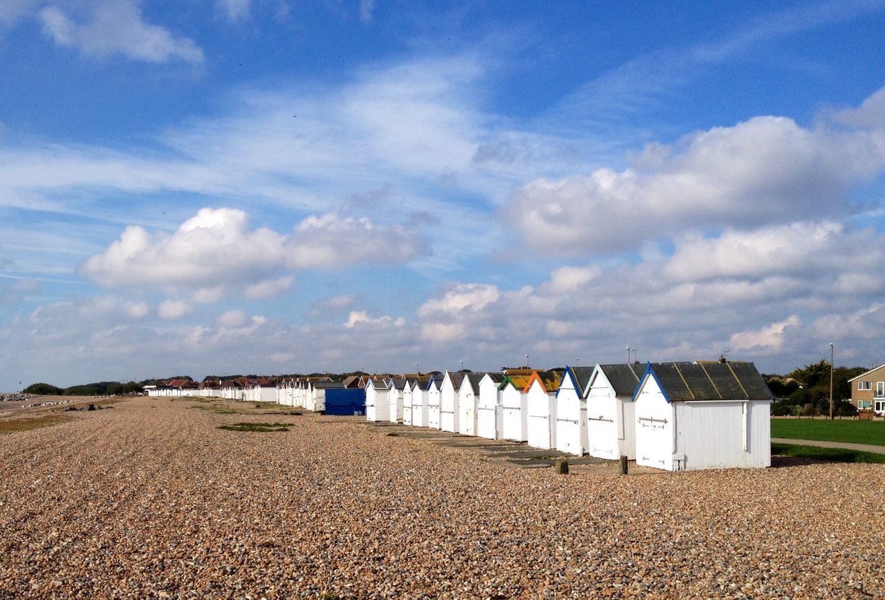 sky, beach, cloud - sky, sand, cloud, blue, cloudy, built structure, shore, tranquility, tranquil scene, nature, water, day, sea, scenics, architecture, building exterior, outdoors, beauty in nature