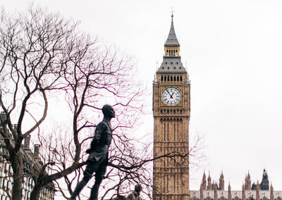 Low angle view of clock tower amidst buildings in city