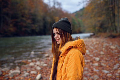 Woman wearing hat against trees during autumn