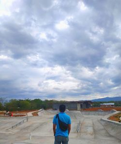 Rear view of man looking at city against sky