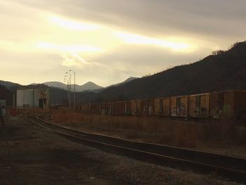 Railroad tracks against sky during sunset