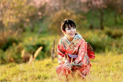 Smiling young woman standing on field