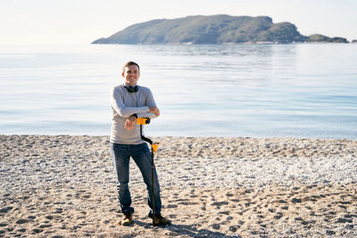 Portrait of young man standing at beach