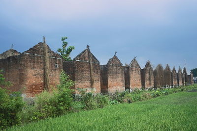 Old temple on field against sky