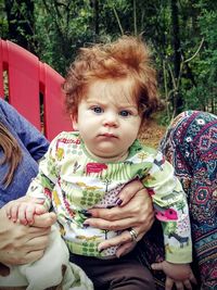 Midsection of mother carrying daughter at park