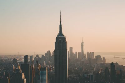 Aerial view of modern buildings in city against sky during sunset