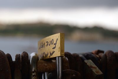 Close-up of padlocks on railing against blurred background