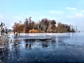 Scenic view of lake against sky during winter