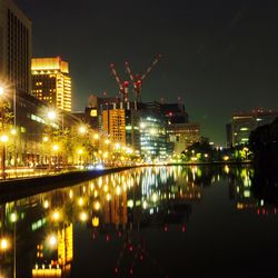 Illuminated city against sky at night