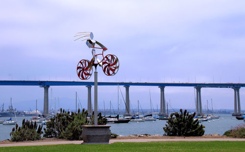Bicycle by sea against sky