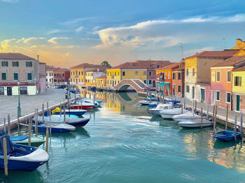 Boats moored at harbor against buildings in city