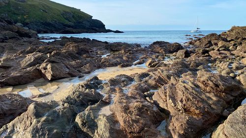 Scenic view of rocks on beach against sky