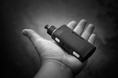 Cropped hand of person holding electronic cigarette