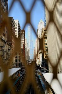 Trump tower against sky in city seen through fence