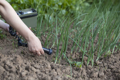 Cropped hands of woman using agricultural machinery on field