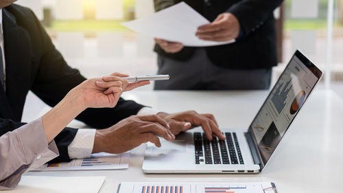 Midsection of man using laptop on table