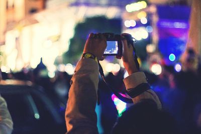 Woman photographing through smart phone at night