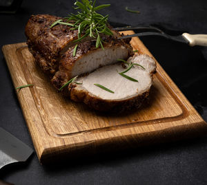 Baked piece of pork meat in spices on a wooden board, cut into pieces. eye of round roast steak