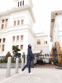 Portrait of woman wearing hijab against building in city