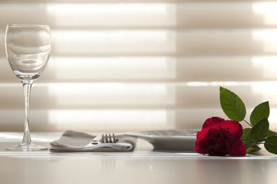 Close-up of rose in glass on table