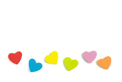 Close-up of colorful heart shaped decorations on white background