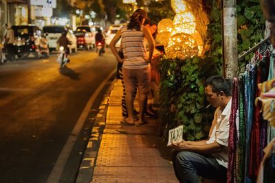 People sitting in illuminated city at night