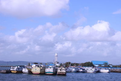 Sailboats moored on sea against sky