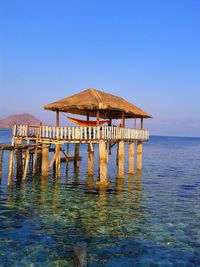 Gazebo on beach against clear blue sky