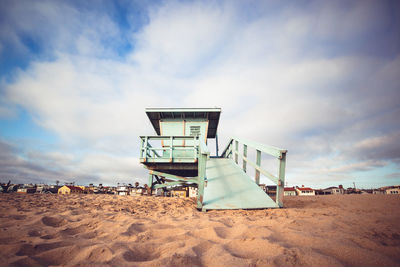 Lifeguard hut on beach against sky