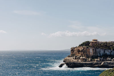 Scenic view of sea and cliff against sky