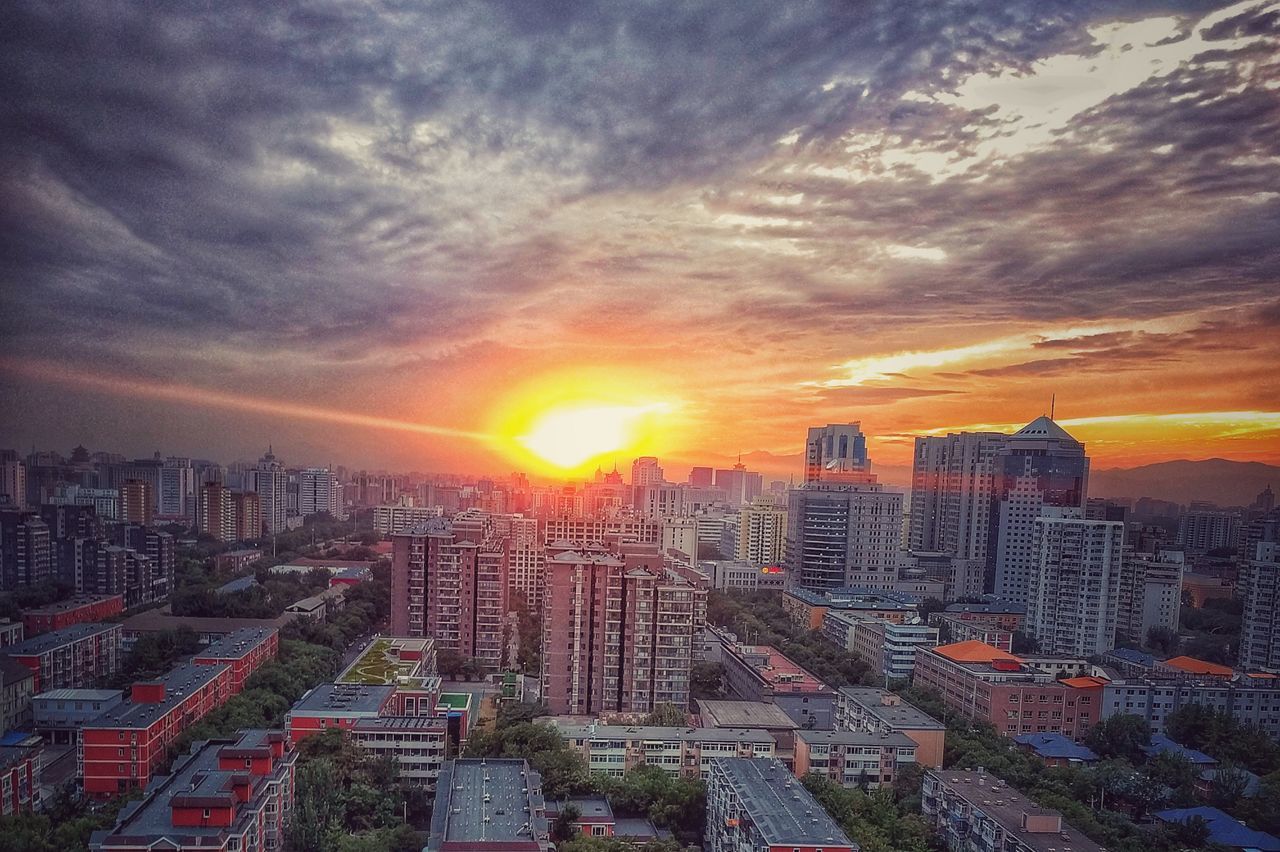 HIGH ANGLE VIEW OF MODERN BUILDINGS AGAINST SKY AT SUNSET